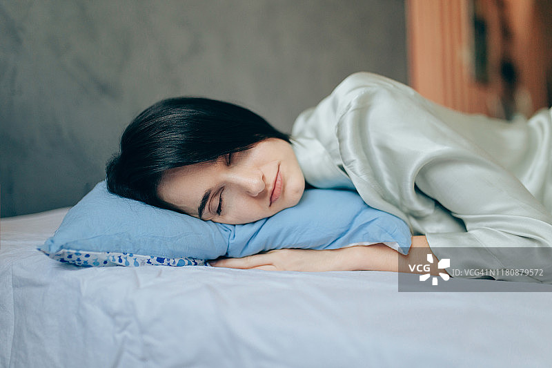 年轻漂亮的女人在床上睡觉图片素材