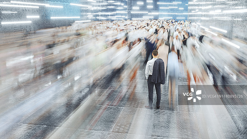 站在快速移动的通勤人群中的商人图片素材