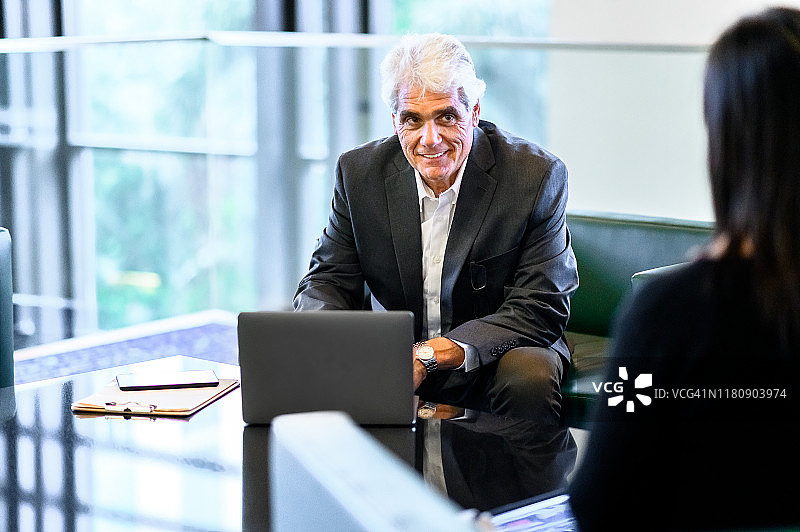 同事们在轻松的会议中用笔记本电脑面试图片素材