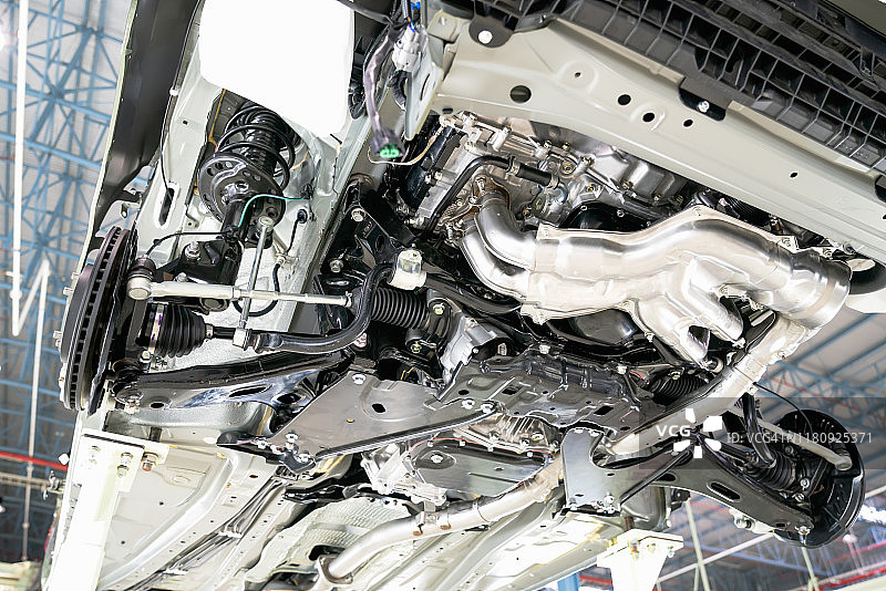 商业底盘在机舱下，不同气动、电气设备和各种零件细节的特写镜头。汽车修理厂。汽车在升降机上进行检查维护修理。图片素材