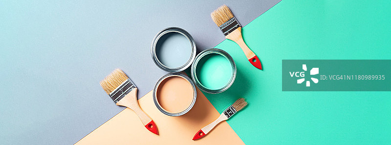 彩色背景上的金属漆罐和画笔，顶部视角图片素材