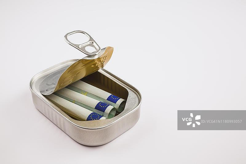 德国，白色背景上银色铝罐中的三张卷起来的100欧元纸币图片素材