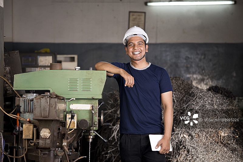 维护工程师站在工厂的机器旁图片素材