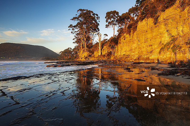日出时分，悬崖倒映在棋盘格路面上图片素材