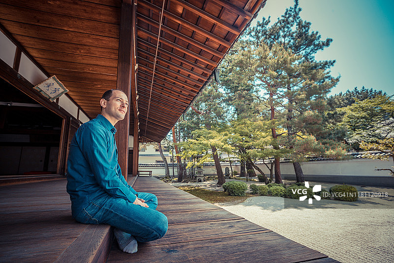 在寺庙花园中放松的白人男人图片素材
