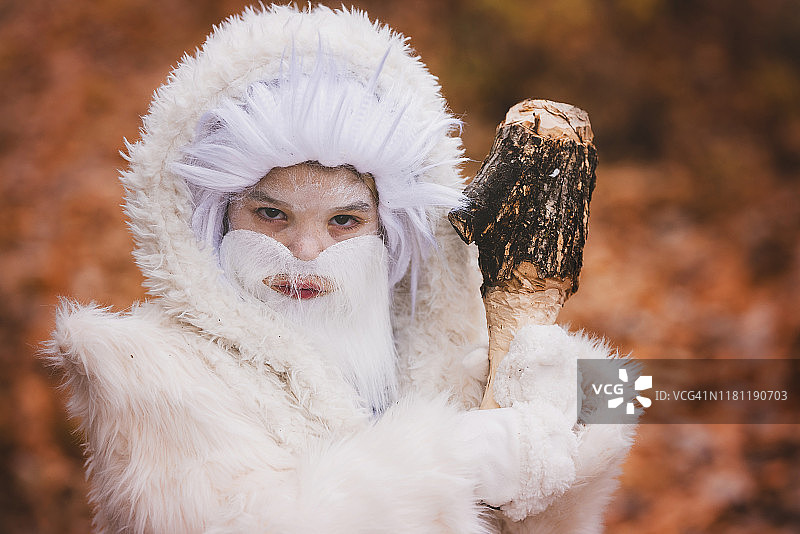 万圣节，装扮成白色雪怪站在森林里的男孩，美国图片素材