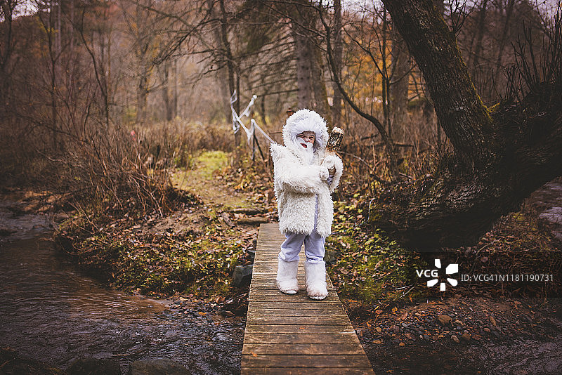 万圣节，男孩打扮成白色雪怪过桥（美国）图片素材