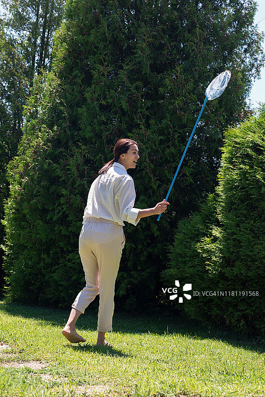 在保加利亚花园里手持捕蝶网的女人图片素材