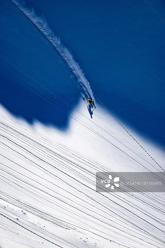 航拍视角：一名男子在奥地利达赫斯坦冰川上进行野外粉雪滑雪图片素材