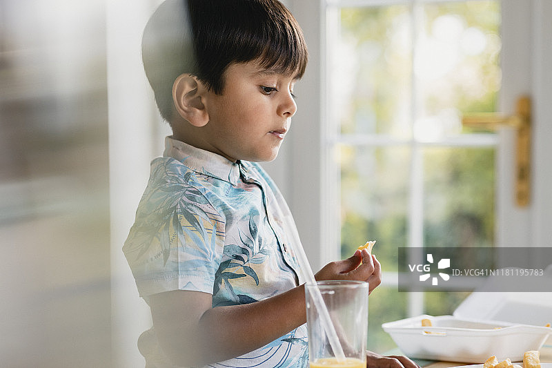 正在吃零食和饮料的小男孩图片素材