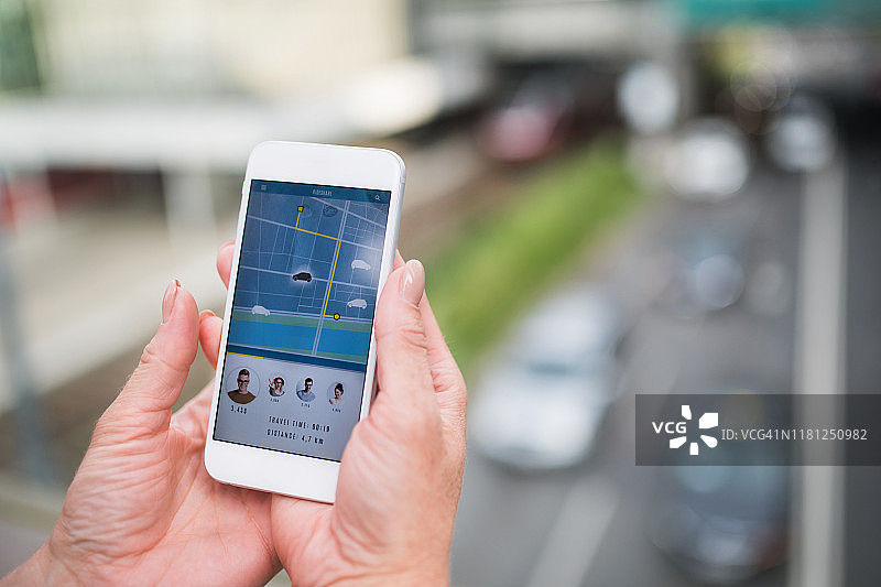 女人手持智能手机的身体中部视角，汽车共享概念图片素材