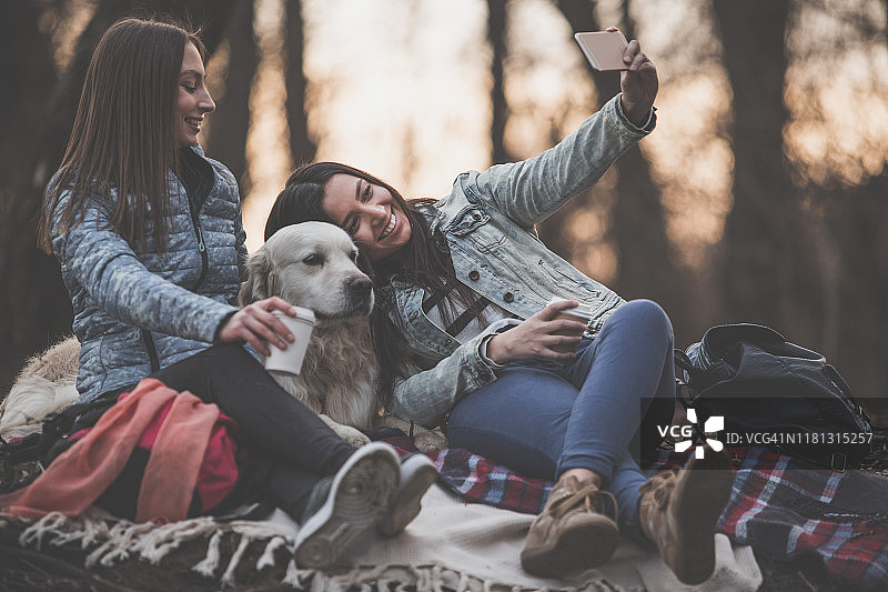 快乐的年轻女子和宠物狗在户外自拍图片素材