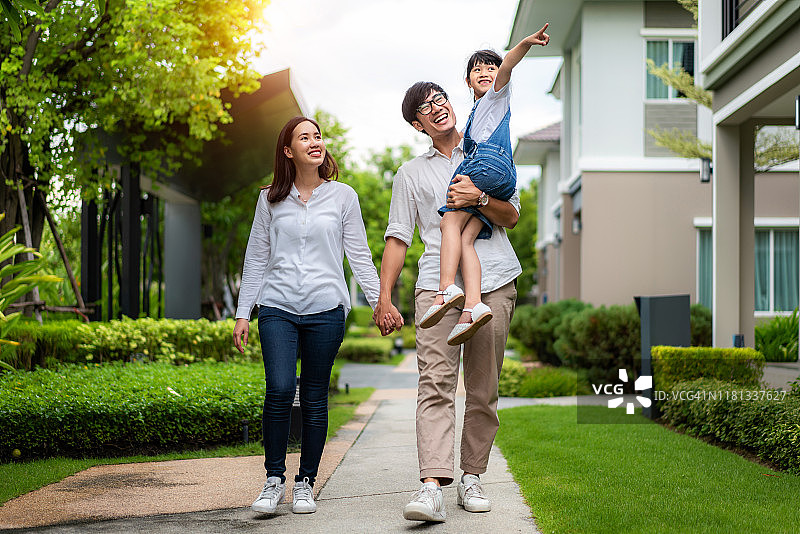 亚洲家庭在村庄新房前散步图片素材