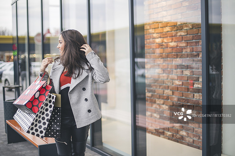 时尚美丽的购物女郎。在购物中心提着购物袋的女人图片素材