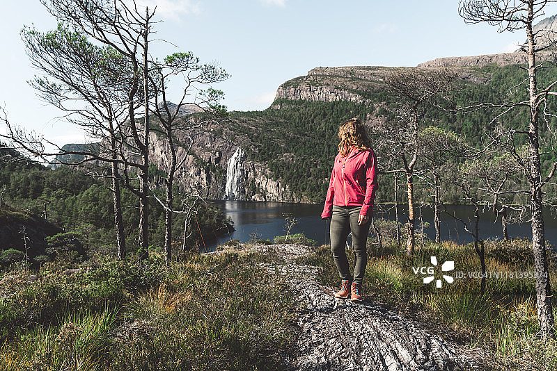 徒步女子站在山上眺望新娘面纱瀑布图片素材
