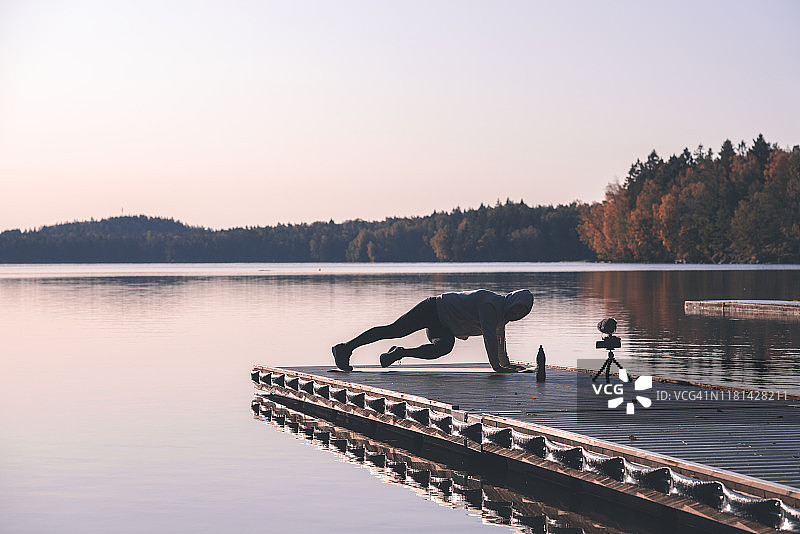健身网红在黎明时分的户外录制健身视频图片素材