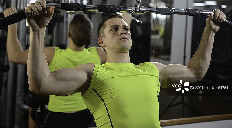 健美运动员在划船机上锻炼图片素材