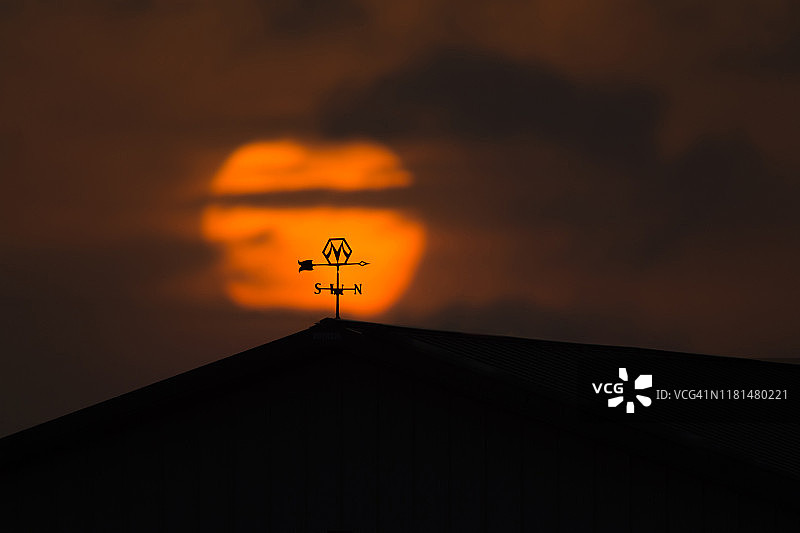 内布拉斯加州普拉特河沿岸日出时谷仓屋顶上的风向标图片素材
