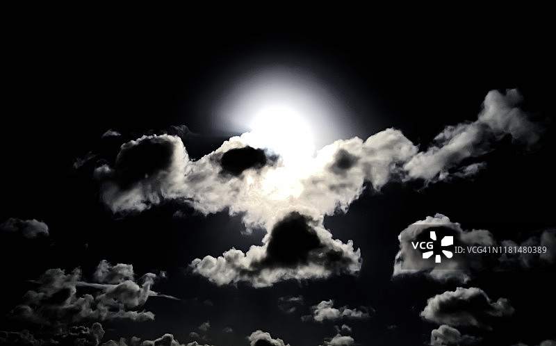 满月照亮多云的黑暗夜空图片素材