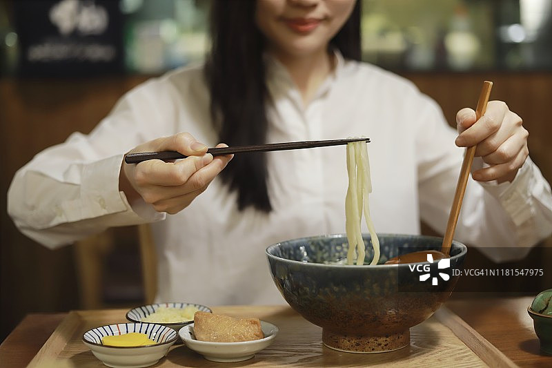 在餐厅吃乌冬面的女人图片素材