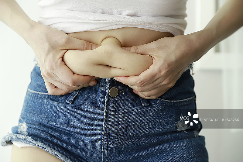 女人捏肚子上的赘肉图片素材