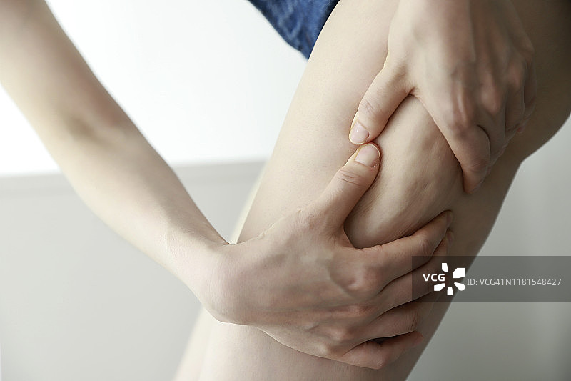 女人捏大腿上的橘皮组织，特写图片素材