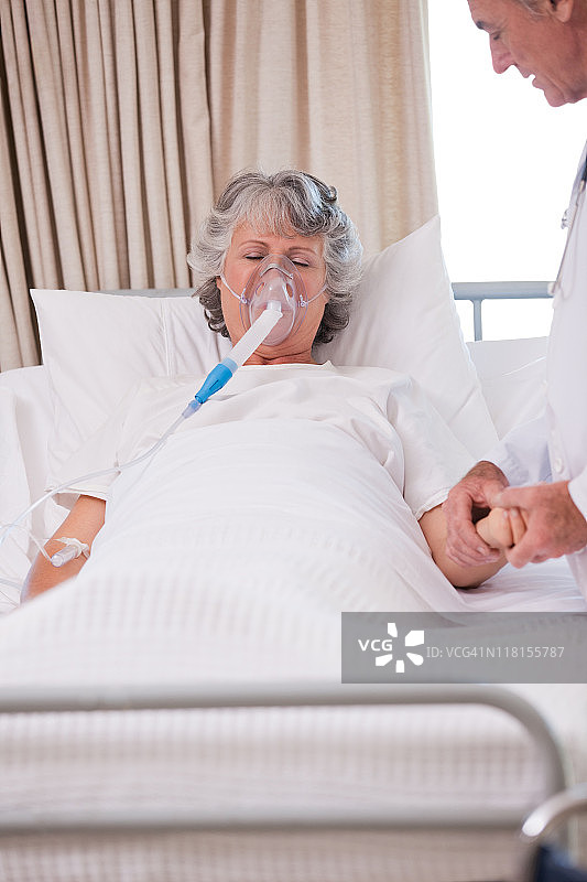 和生病患者在一起的年长医生图片素材