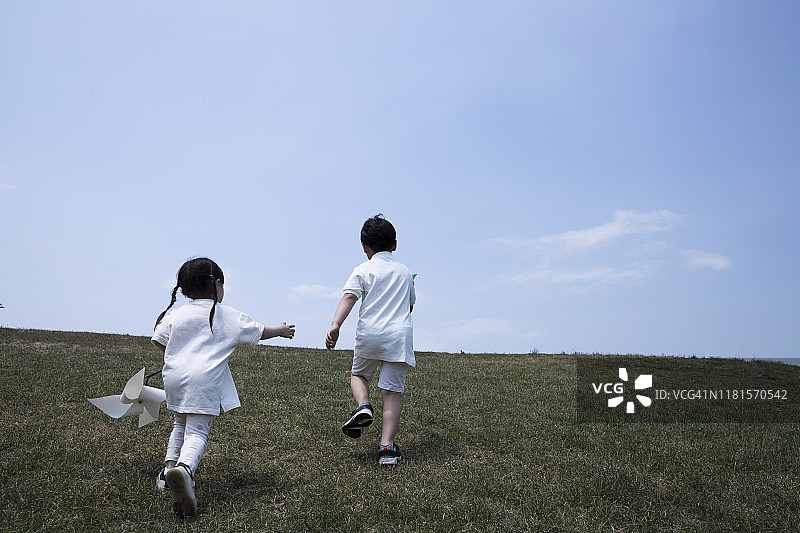 孩子们在草地上玩风车图片素材