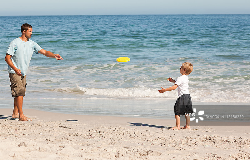 和小男孩一起玩飞盘的父亲图片素材
