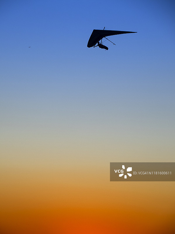 夕阳下的悬挂式滑翔机图片素材