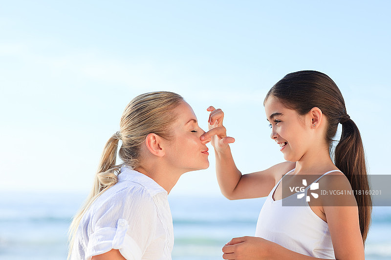 小女孩给她的母亲涂防晒霜图片素材