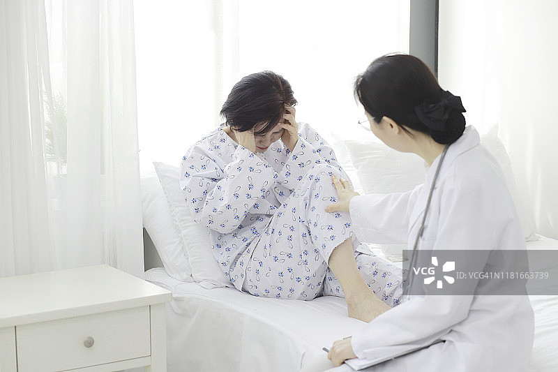 医生在医院病床上检查病人的头痛图片素材