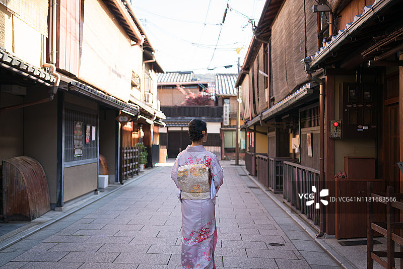 在京都祇园东山地区空旷街道上漫步的年轻和服女子图片素材