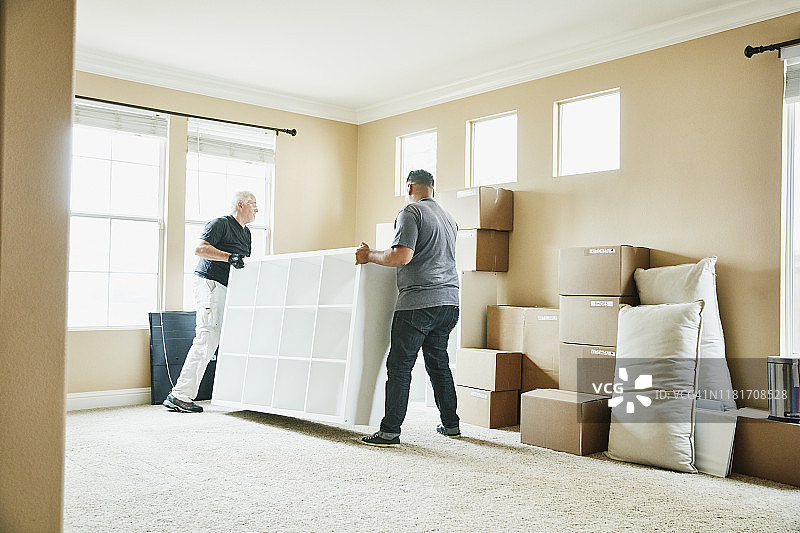 岳父和女婿在搬家当天移动客厅里的书架图片素材