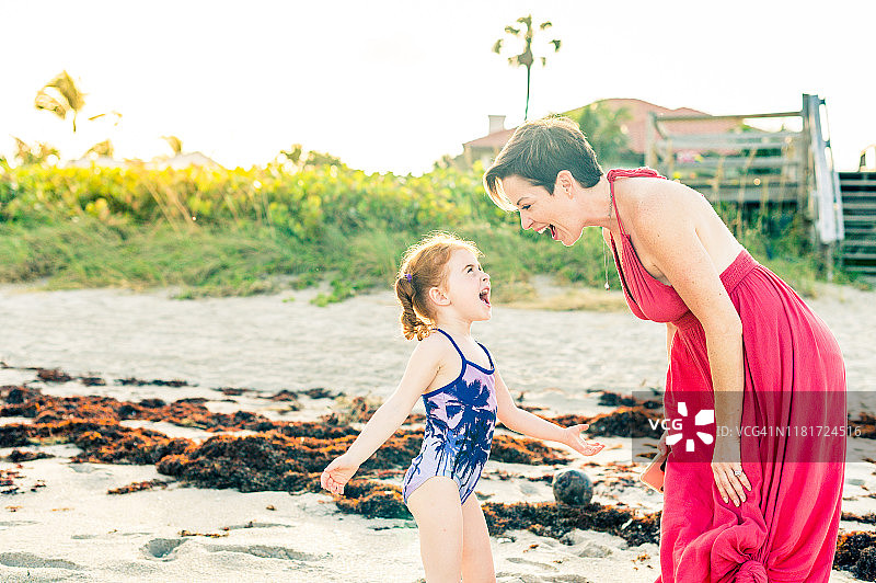 在海滩上美丽的母亲和快乐的红发女儿图片素材