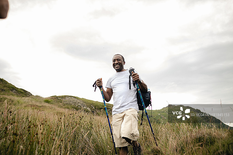 年长的男人拄着棍子在山里徒步旅行图片素材