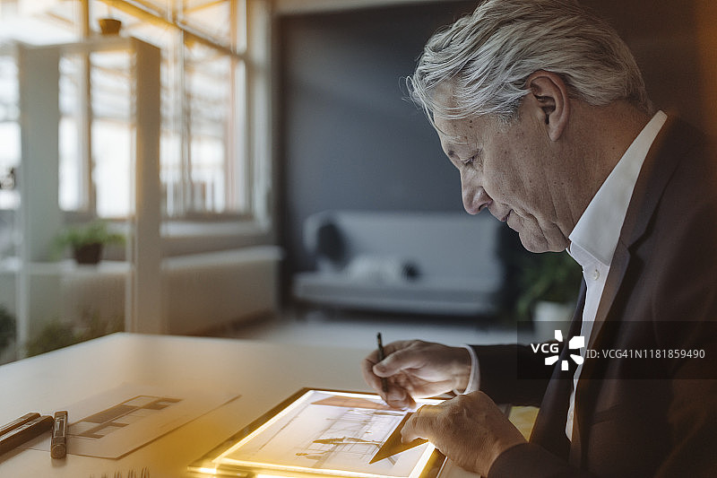 年长的商人在发光的平板电脑上绘画图片素材