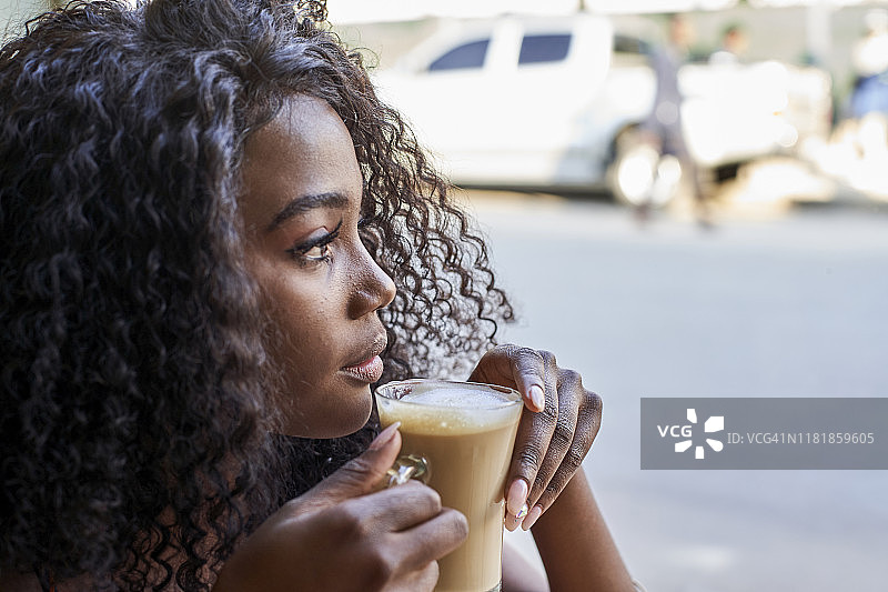 在咖啡馆靠窗边的年轻非洲女性肖像图片素材