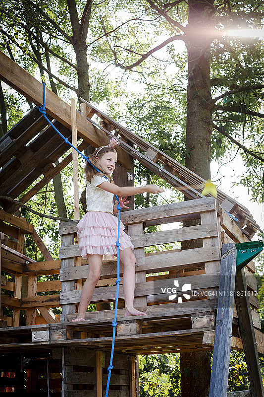 装扮成公主的女孩在树屋里玩耍图片素材