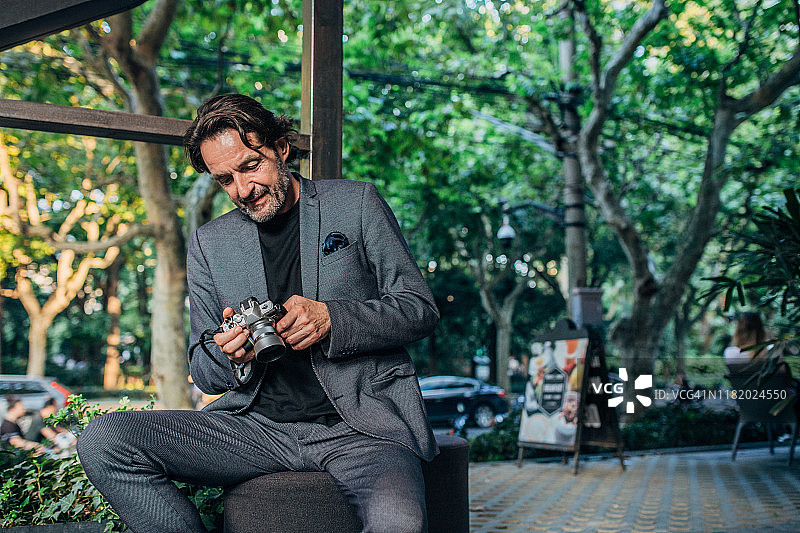 看着相机上照片的成熟商人图片素材