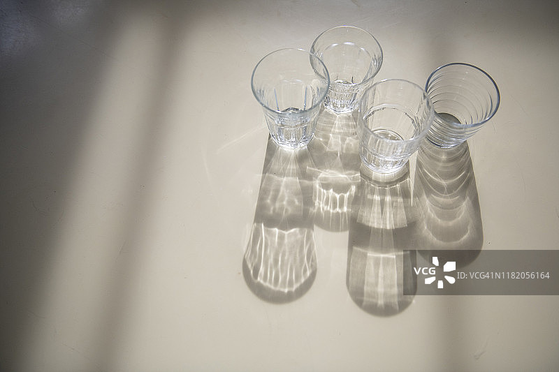 桌上多种玻璃杯，阳光光影效果图片素材