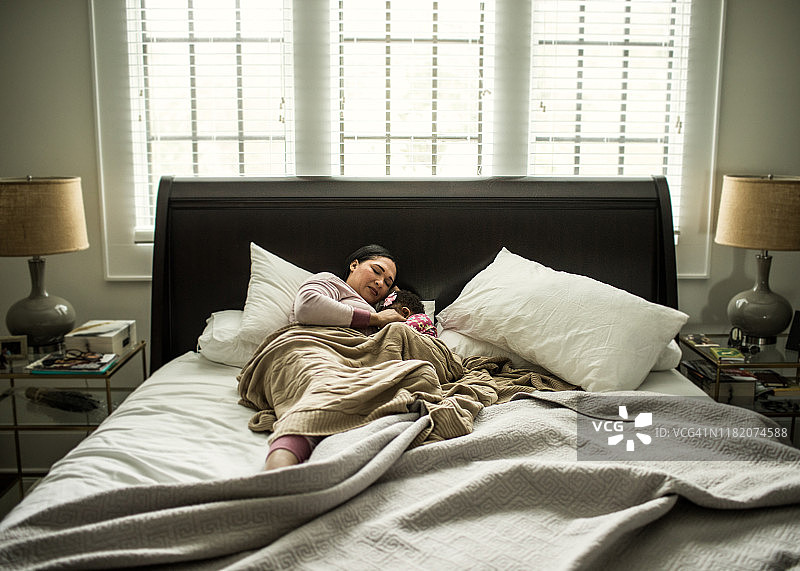 母亲在卧室给18个月大的女儿哺乳图片素材