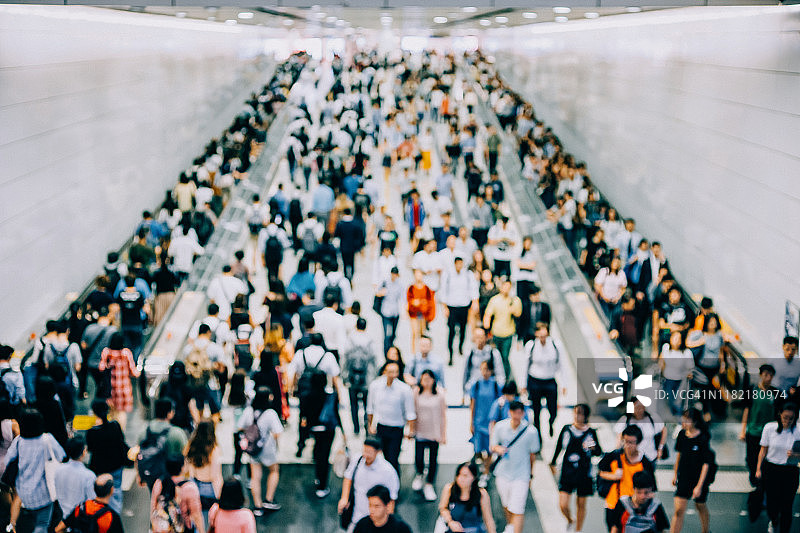 城市高峰时段地铁站台上繁忙通勤者的虚化背景图片素材