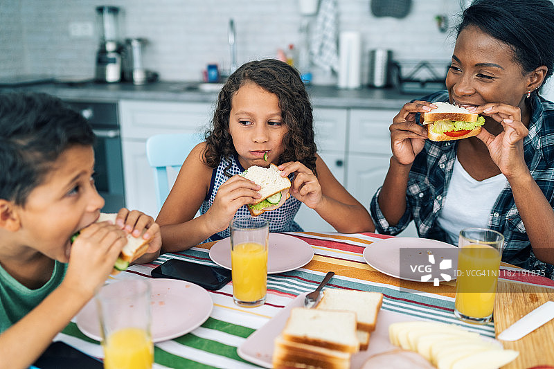母亲和孩子们吃三明治图片素材