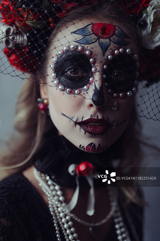 面部画着巫毒彩绘的年轻女子图片素材