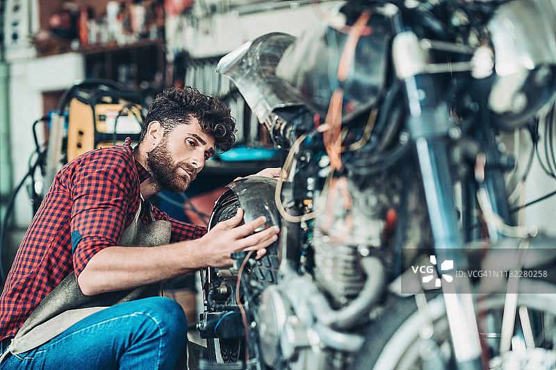 男人在车库修理摩托车图片素材