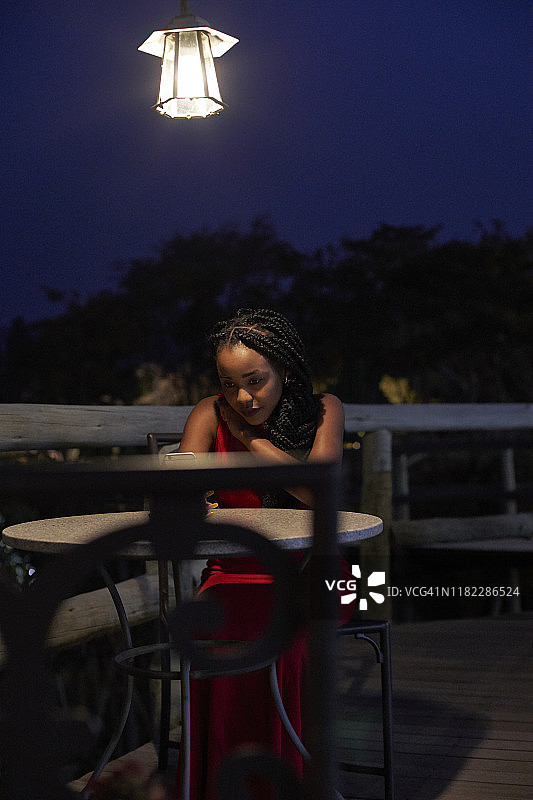 在露台上查看智能手机的年轻女子图片素材