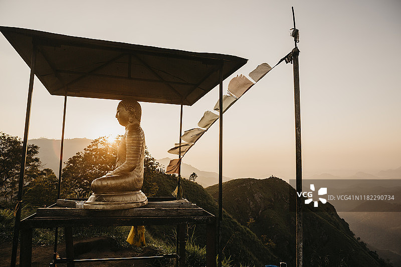 斯里兰卡小亚当峰山顶的佛像，背景是日落天空图片素材