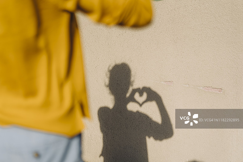 用手比心的女人身影图片素材