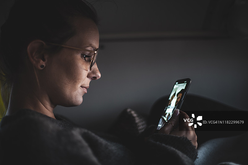 在面包车里，女人在视频聊天时看着她的智能手机图片素材